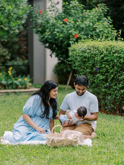A wider shot of the family enjoying their outdoor newborn session, capturing the peaceful and natural setting.