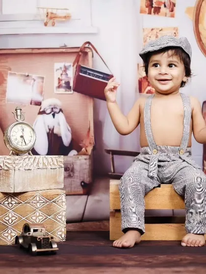 A happy toddler playing with props in our vintage traveler themed studio.
