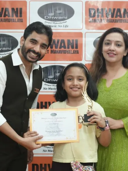 A student, her mother, and a teacher celebrate her win at the Dhwani Kala Mahotsav.