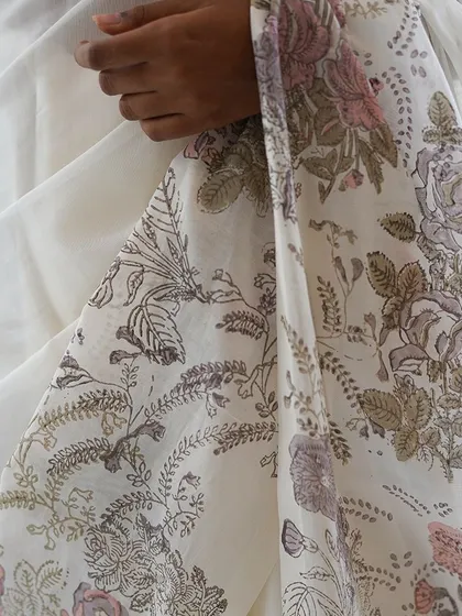 The Mallika saree is a breath of fresh air, crafted in custom linen with a woven border. Its design features a joyful bouquet of vintage jacaranda, rose, and petal block prints, accented with delicate hand-embroidered details for a light, breezy feel.
