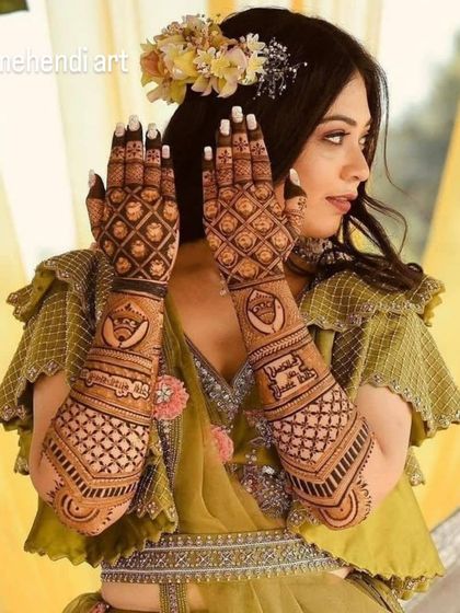 A beautiful shot of a bride with her personalized mehendi, which includes her name and other custom elements woven into a traditional pattern.