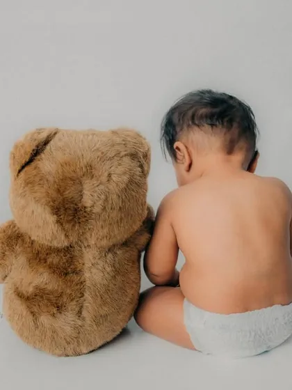 Sharing a secret with his best friend. This back shot is an adorable and unique take on the classic baby and teddy bear photo.
