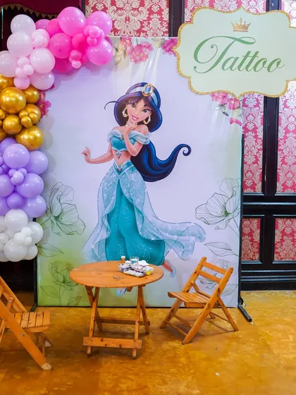A tattoo station with a Princess Jasmine backdrop, offering fun, temporary tattoos for all the guests.