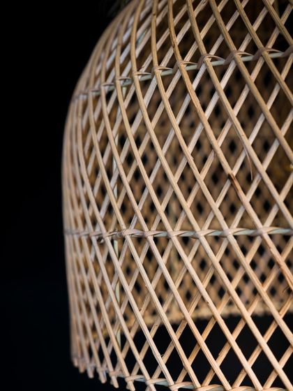A close-up on the dome lamp's rattan weave. Each strand is precisely placed by hand to create a pattern that is both beautiful and structurally sound.