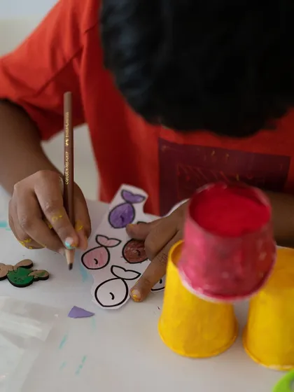In my classes, we often use simple materials to create amazing things. This student is coloring fish cutouts that will become part of a larger mixed-media sculpture. It's all about imagination and resourcefulness.