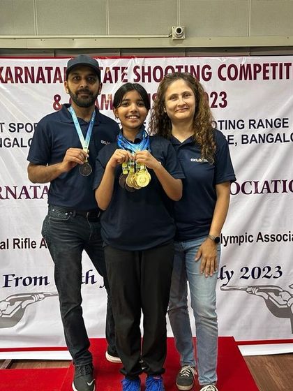 A proud family moment on the winner's podium. We recognize that support from family and coaches is crucial to a shooter's success.