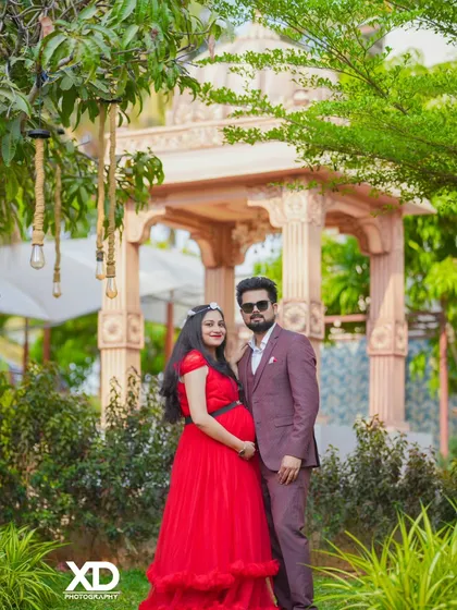 A stylish couple's portrait in a garden, with sunglasses adding a cool, modern touch.