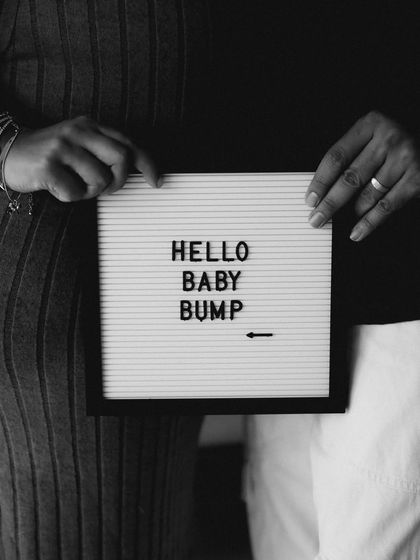 A classic black and white close-up of the "Hello Baby Bump" sign. It's a clean, minimalist, and stylish way to share the news.