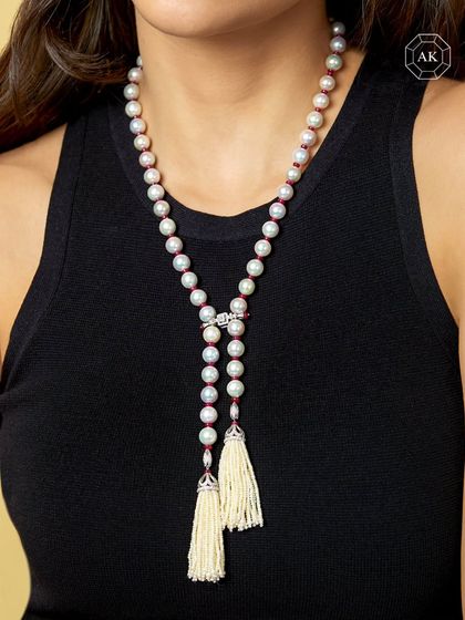 A single string of luminous South Sea pearls, accented with delicate rubies and finished with two fur tassels crowned with diamonds.
