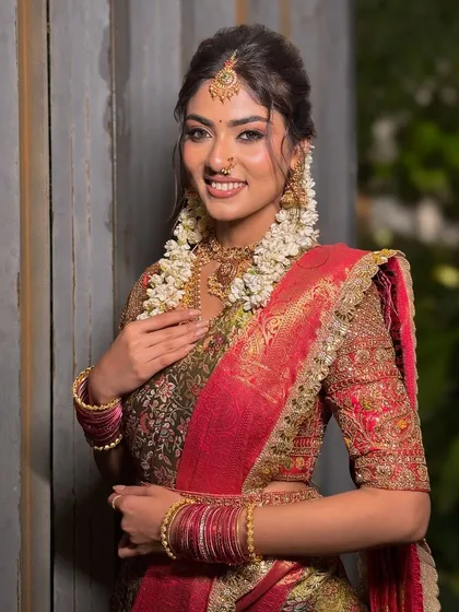 A beautiful portrait of a South Indian bride, her makeup enhancing her natural features and complementing her traditional attire.