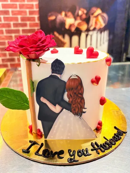 A romantic anniversary cake with an illustration of a couple and the message "I Love you Husband".