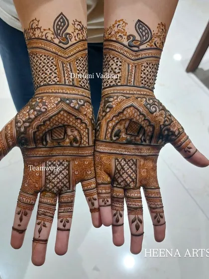 This design features elephants within traditional arches on the palm, with peacocks on the wrist.