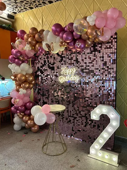 The full view of the chic 2nd birthday party decor with a shimmer wall and marquee number.