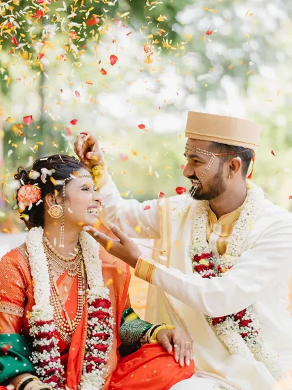 A shower of colorful petals rains down on Vicky and Aishwarya. This vibrant, joyful shot captures the celebratory spirit of their Maharashtrian wedding ceremony.