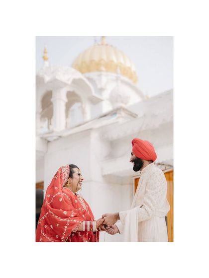 A beautiful portrait of Kushmeet and Aishwarya in front of the Gurudwara. The architecture frames them perfectly, symbolizing their union in a place of faith and tradition.