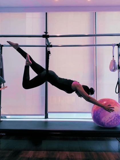 A variation of the previous pose, adding a leg bend to deepen the stretch and challenge stability further. The Cadillac allows for creative and beautiful movements.