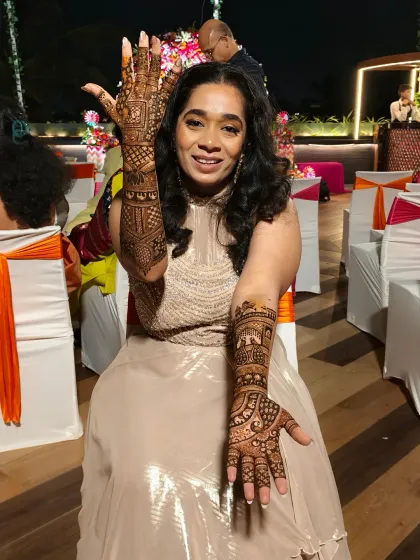 The happy bride showing off her completed royal-themed mehndi.