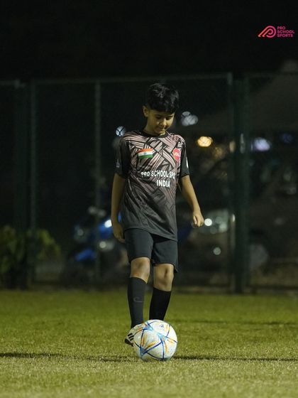 A young player stands confidently with the ball, ready for the next drill.