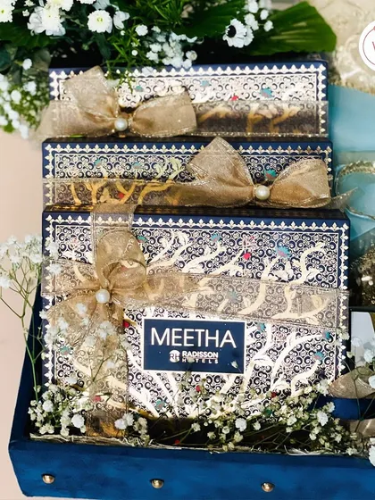 This is an example of my bespoke trousseau packaging. I designed this royal blue velvet case to hold intricately detailed 'Meetha' boxes for the groom's family. It's a grand gesture, a symbol of the bond between two families.