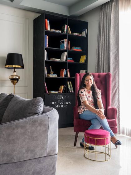 The designer, Saakshi Jaggi, in a cozy reading corner of a completed project. This image connects the designer to the beautiful spaces she creates, adding a personal touch.