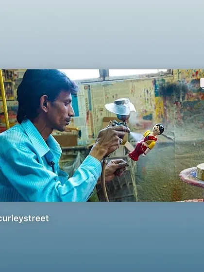 An artisan applies a fine coat of lacquer using a spray gun. This modern technique helps us ensure a durable, even finish while still using our traditional, safe, and natural coloring materials.