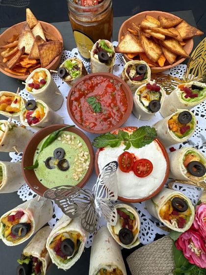 A platter of our Mexican burrito bites, beautifully arranged with fresh salsas and dips. The silver butterfly accents add a touch of our signature whimsical elegance.