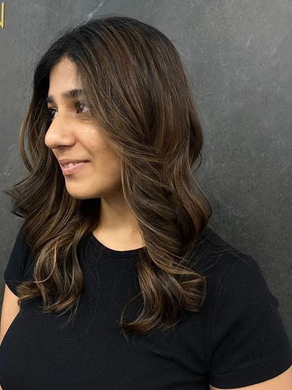 Rocking this vibrant hair journey with soft, face-framing waves and subtle highlights.