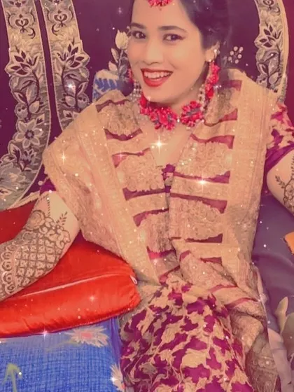 A smiling bride ready for her function. The henna design complements her beautiful outfit and floral jewelry perfectly.