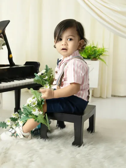 A sweet moment with a bouquet of daisies. The combination of the classic outfit and soft florals creates a charming and gentle portrait.