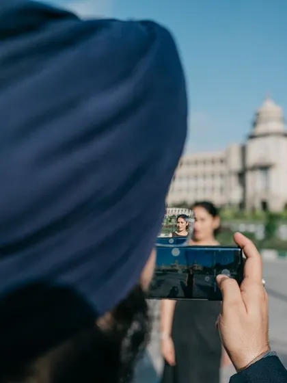 A duplicate of image 24, a creative shot capturing a photo within a photo, with Bangalore's Vidhana Soudha in the background.