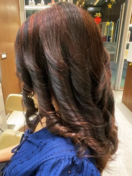 It's all about the curls. This style shows off a beautiful blend of dark hair with subtle red undertones, creating a very sophisticated look.