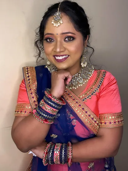 A beautiful lehenga look with a pink and blue color combination. The makeup is soft and pretty, with a focus on pink tones to match the outfit.