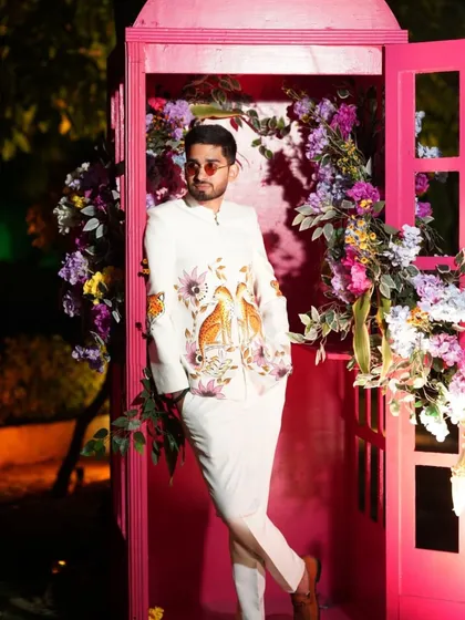 A closer look at the custom white bandhgala jacket in its element. The hand-painted design is crafted to be a conversation starter, making it the perfect choice for a stylish wedding guest or groom looking for unique ceremonial wear.