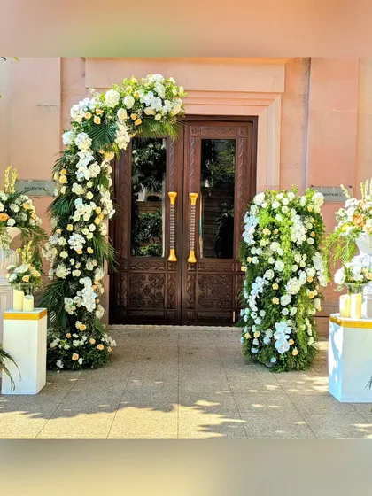 This outdoor entrance for Saloni and Himanshu's wedding featured a beautiful arch of white and peach florals, creating a fresh and romantic welcome against the classic architecture.