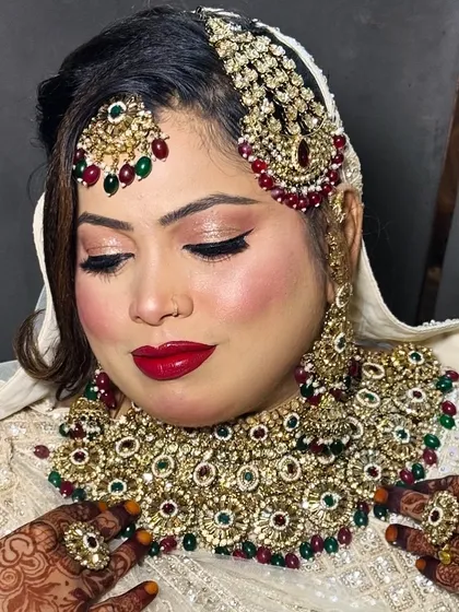 This bride wanted a classic Nikkah look with a bright red lip. I paired it with soft, shimmery eyeshadow and a sharp winged liner to define her eyes, creating a look that was both bold and beautiful.