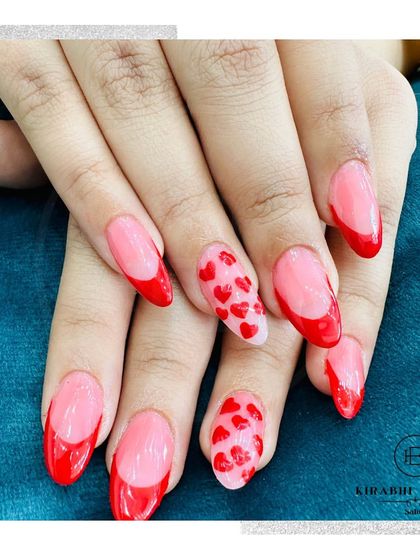 A beautiful close-up of the red French manicure with heart-patterned accent nails. This is a popular choice for festive occasions or just to show some love.
