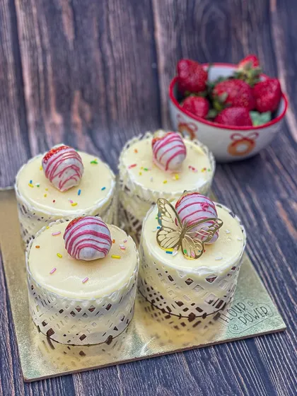 These mini strawberry cakes are individually portioned and decorated with a chocolate lace collar and a white chocolate strawberry truffle.
