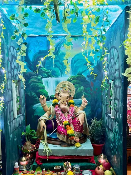 Even a small corner in a home can be transformed into a sacred space. Here, I painted a serene waterfall backdrop on manjarpat cloth and created a 360-degree jungle theme with painted walls and ceiling to welcome Ganpati.