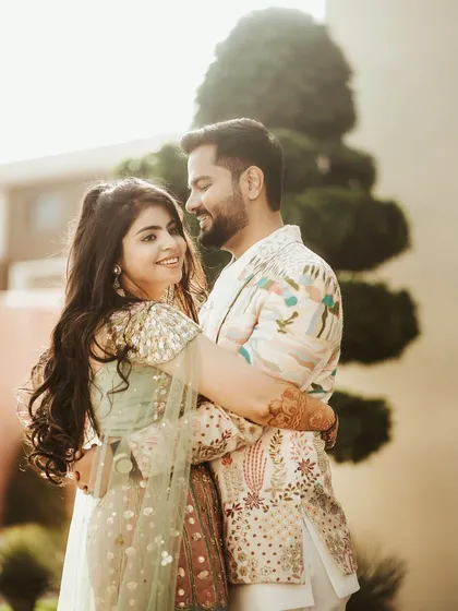 A sun-kissed portrait of the couple, full of warmth and affection. Their happy smiles and close embrace create a beautiful and natural image of their love.