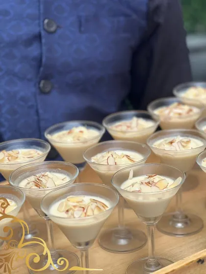 A modern take on a classic Indian dessert, possibly a rich kheer or phirni. Served in martini glasses and garnished with toasted almonds, it's both familiar and fancy.