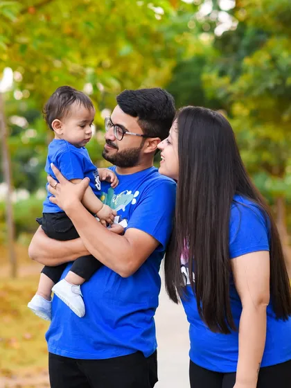 A candid moment of connection between parents and their child during an outdoor family photoshoot.