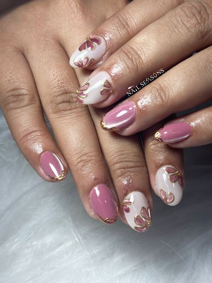 Pretty pink petals with golden edges. This design alternates between solid pink nails with chrome tips and nude nails with hand-painted floral art.