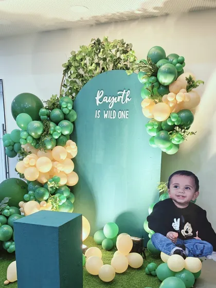 Another angle of Rayirth's "Wild One" birthday setup. This view shows the custom cutout of the birthday boy sitting atop a cloud of balloons, a creative way to make the celebration feel even more personal.