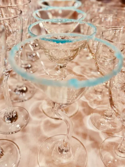 Martini glasses prepped with a vibrant blue sugar rim, adding a pop of color and a hint of sweetness before the cocktail is even poured.