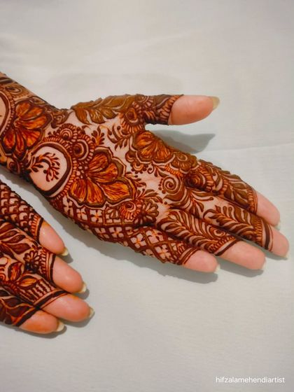 A detailed shot of the palm in the hibiscus flower design, showing the fine lines and intricate fills around the main floral motifs.