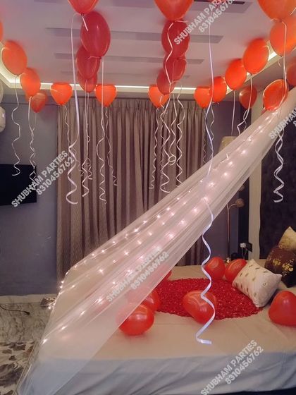 A romantic bedroom setup with a canopy of fairy lights and heart-shaped balloons floating on the ceiling.