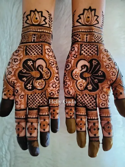 A stylish design perfect for a bridesmaid. It features a central peacock motif surrounded by a mix of geometric and floral patterns, with the fingertips left open.