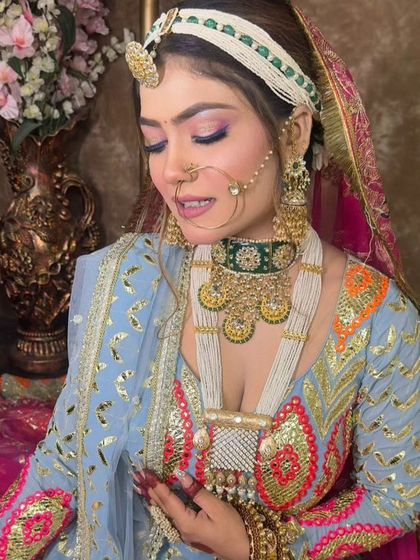 A side profile of a bride in a Rajasthani look, highlighting the layered necklaces and the intricate design of the borla and nath.