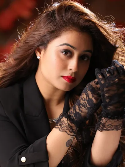 A glamorous, high-fashion close-up of actress Megha Sharma. The bold red lip and lace gloves create a classic, cinematic feel, highlighting her ability to carry a strong, stylized look.