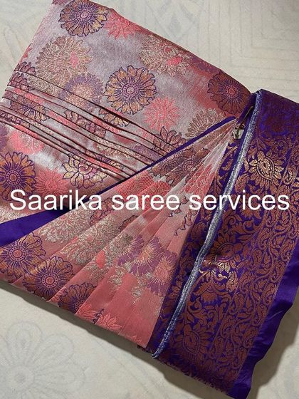 A beautiful floral printed saree with a rich purple border. The pleats are set to highlight the lovely design.